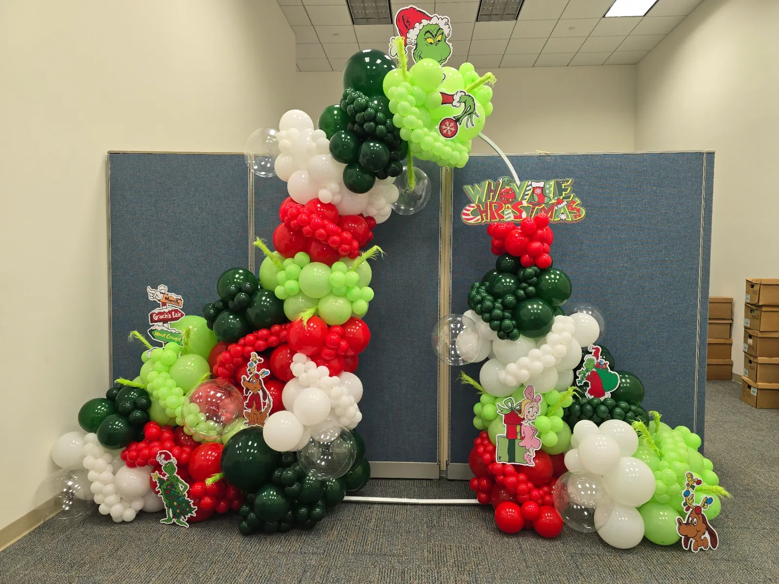 Grinch-themed red, green and white organic balloon arch installed for a corporate holiday party in South Florida