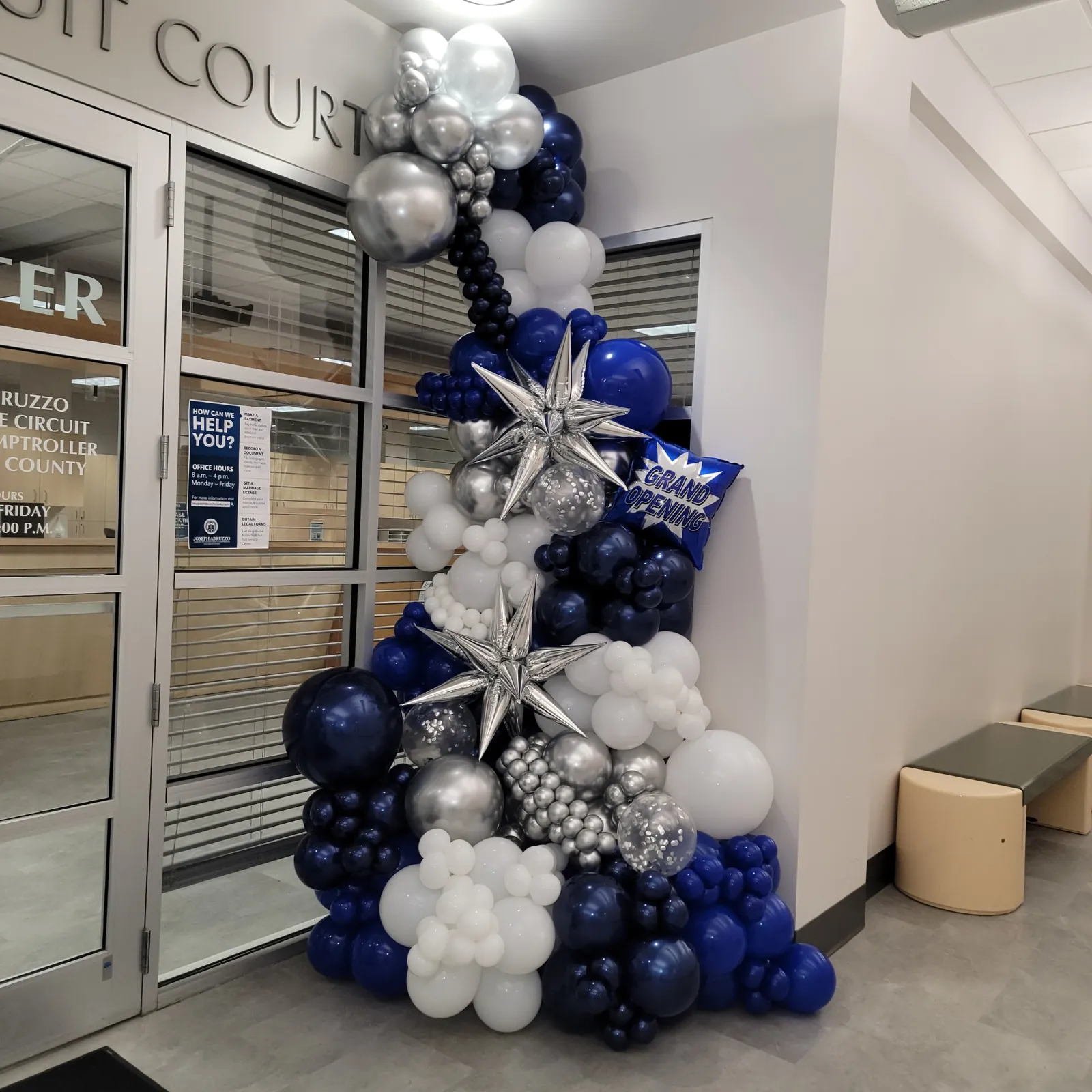 Navy, silver and white grand opening balloon installation at a Palm Beach County courthouse service center