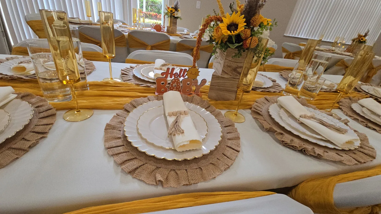 Sunflower baby shower tablescape with mustard runners, burlap ruffle chargers and gold glassware